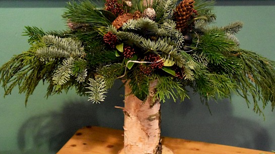 Kerststuk op houten boomstam